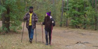 徒步旅行者夫妇在森林小径上拿着登山杖