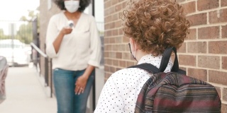 2019冠状病毒病大流行期间，一名学童在学校体温检查点排队