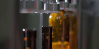 用机器把葡萄酒装瓶到棕色玻璃制成的瓶子里