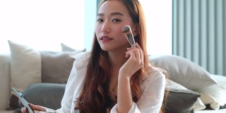 年轻的亚洲女人化妆