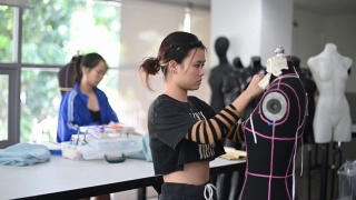 亚洲华人大学时装学生在课堂上研究他们的时装设计视频素材模板下载