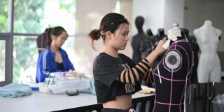 亚洲华人大学时装学生在课堂上研究他们的时装设计