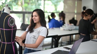 亚洲大学时装学生在课堂上与人体模型一起进行时装设计项目视频素材模板下载