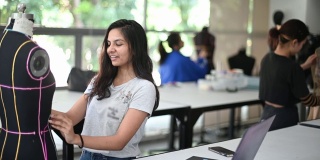 亚洲大学时装学生在课堂上与人体模型一起进行时装设计项目