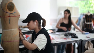 亚洲华人大学时装学生在课堂上研究他们的时装设计视频素材模板下载