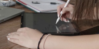 COVID-19大流行期间的在家教育。专注于用笔记本电脑上在线课程的学生。青少年在线学习和在她的数字平板电脑上做笔记。社会距离。