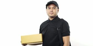 微笑年轻的亚洲快递员在黑色制服拿着包裹盒子和袋子站在孤立的白色背景。4 k决议。