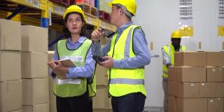 亚洲仓库经理持有条码扫描仪培训实习生女工在仓库工厂控制库存和检查清单库存。新员工向主管学习工作