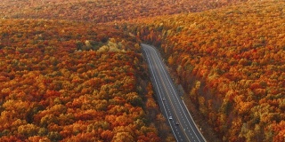 高速公路上的群山在清晨，夕阳刚落，就进入了五彩缤纷的秋季。无人机视频与加速平移摄像机运动。