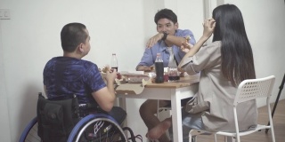残疾人坐在轮椅上和朋友一起庆祝。
