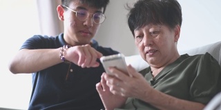 亚洲华人高级妇女看她的手机检查信息社交媒体上网冲浪