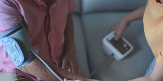 在女儿的帮助下，一名亚裔华人老人正在检查血压