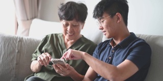 亚洲华人高级妇女看她的手机检查信息社交媒体上网冲浪