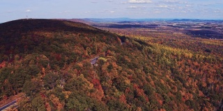 遥远的风景鸟瞰公路上的阿巴拉契亚山脉与遥远的利哈伊山谷，波科诺斯，宾夕法尼亚州，在秋天的傍晚的背景。航拍视频与平移摄像机运动。