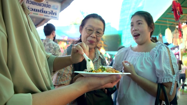 泰国街头小吃。她们来市场观光，那里是夜生活的场所，是吃饭的好地方。