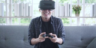 亚洲年轻人用VR眼镜和遥控器玩游戏