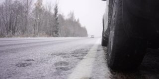 汽车行驶在积雪覆盖的冬季道路上