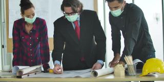 土木工程师、建筑师、室内设计师戴口罩预防冠状病毒爆发/新冠肺炎，会议、检查、总结建筑施工项目蓝图。业务、团队合作的概念。