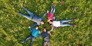 空中一家人和三个孩子围成一圈躺在草地上
