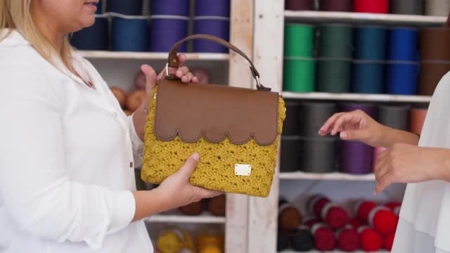 在手工作坊购买手工编织手提包的妇女