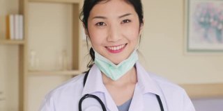 亚洲女医生戴上防护口罩，预防冠状病毒大流行。医护人员在医院穿医生袍戴口罩的妇女肖像。健康职业新常态生活方式。