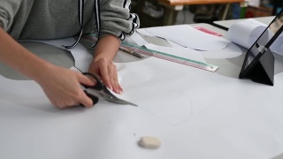 亚洲华裔女时装大学生在学院车间裁剪纸形缝制图案做服装项目视频素材模板下载