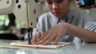亚洲华裔女时装大学生在大学工作坊做服装缝纫项目视频素材模板下载