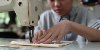 亚洲华裔女时装大学生在大学工作坊做服装缝纫项目