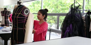 亚洲印度女时装大学生裁剪布料在大学工作坊做服装项目