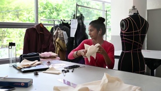 亚洲印度女时装大学生裁剪布料在大学工作坊做服装项目视频素材模板下载