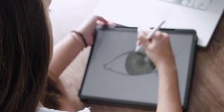 COVID-19大流行期间的在家教育。专注于用笔记本电脑上在线课程的学生。青少年在她的数字平板电脑上进行电子学习和绘画。社会距离。