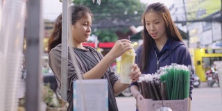 市场小贩从搅拌机中倒出水果冰沙。泰国街头小吃摊。