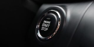 在汽车里，人们按下按钮启动引擎。用按钮发动汽车引擎。特写镜头