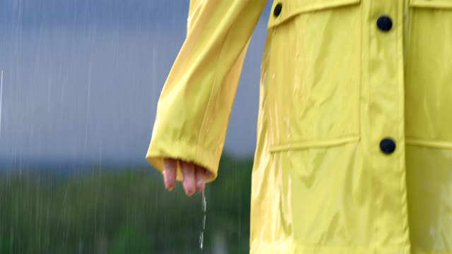 SLO MO女人穿着雨衣享受雨