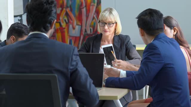 在办公室会议室举行专业多元化的商界人士和商界女性同事团队会议，讨论和头脑风暴商业战略理念，为成功的商业项目