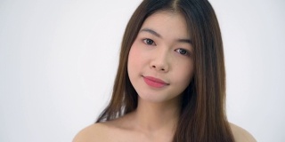 年轻的亚洲20多岁的女人黑色光滑的头发化妆品化妆漂亮的脸看起来在白色的背景上表达情感，病毒剪辑或广告