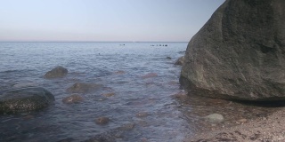 波浪冲刷着一块巨石。波罗的海沿岸。