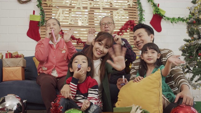 亚洲幸福家庭看着镜头微笑和挥手。
