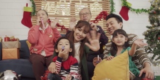 亚洲幸福家庭看着镜头微笑和挥手。