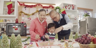 亚洲祖父母和小男孩在做饼干和面包店在圣诞节