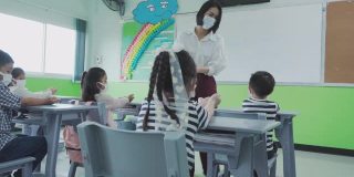 一组亚洲小学生和教师在开学后细菌的传播，新常态的教育理念。
