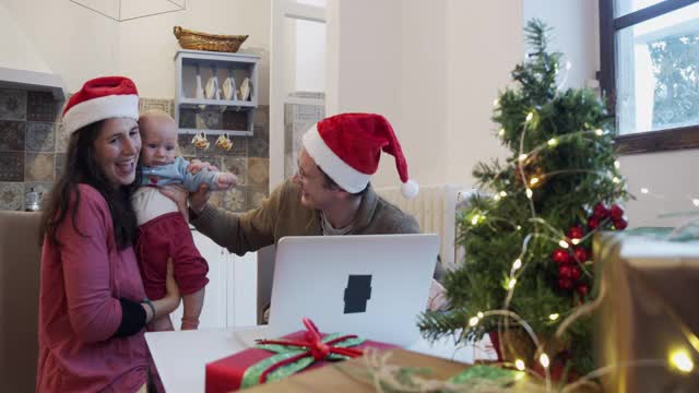 一个家庭庆祝圣诞节的慢动作视频，和他们的亲戚进行视频通话