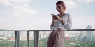 年轻的亚洲女性在家里使用现代智能手机
