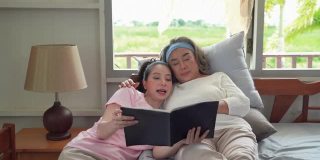 女儿给一位上了年纪的母亲读书，直到她在床上睡着。家庭中温暖的爱