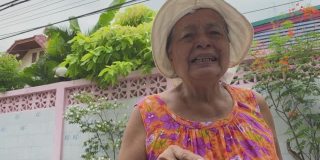 一位年长的亚洲妇女挥手向祖父母说再见