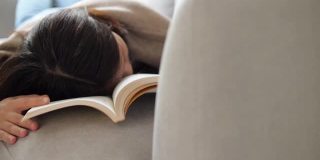 女人在假期在家客厅看书后睡觉和休息