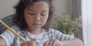 亚洲小女孩在家通过平板电脑做作业和学习。孩子脸的特写