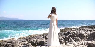 在多岩石的海岸上的新娘，赞美着在岩石上撞击的海浪。