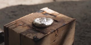 一滴水在热铝上沸腾。砂型铸造熔融铝。将熔化的铝铸入木模中。