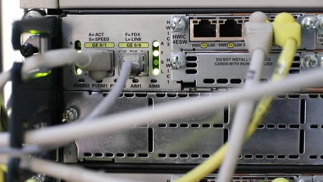 网络硬件。正在进行数据传输，彩色指示灯闪烁。光学纤维。线缆已连接到网络设备。服务器的特写。服务器设备碎片。有选择性的重点。